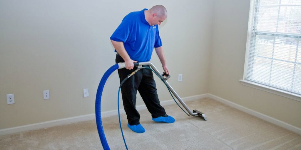 A carpet contractor from J L Williard Carpet Care cleaning a room with a professional carpet cleaning machine in High Point, NC