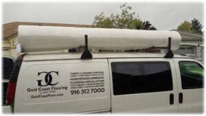 GoldCoast Carpet & Tile Care van carrying a roll of carpet for installation or repair in Sacramento, CA.