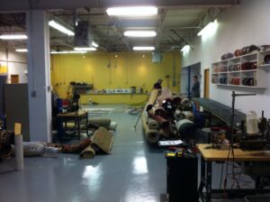 Interior of a carpet contractor workshop with many rolled rugs and equipment at Ziegler Preservation Cleaning in Danbury, CT