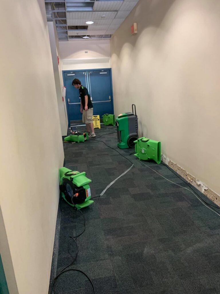 SERVPRO of Tallahassee technicians using carpet drying equipment in a commercial hallway in Tallahassee, FL