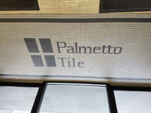 A section of the Palmetto Tile Columbia showroom in Columbia, SC, featuring a carpet flooring display alongside tile samples.