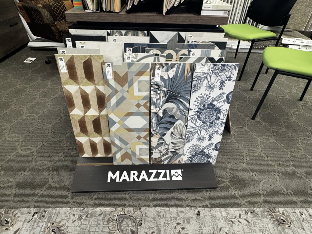 A clean carpeted showroom floor with tile samples in the foreground at 3D Flooring & Design in Mansfield, TX