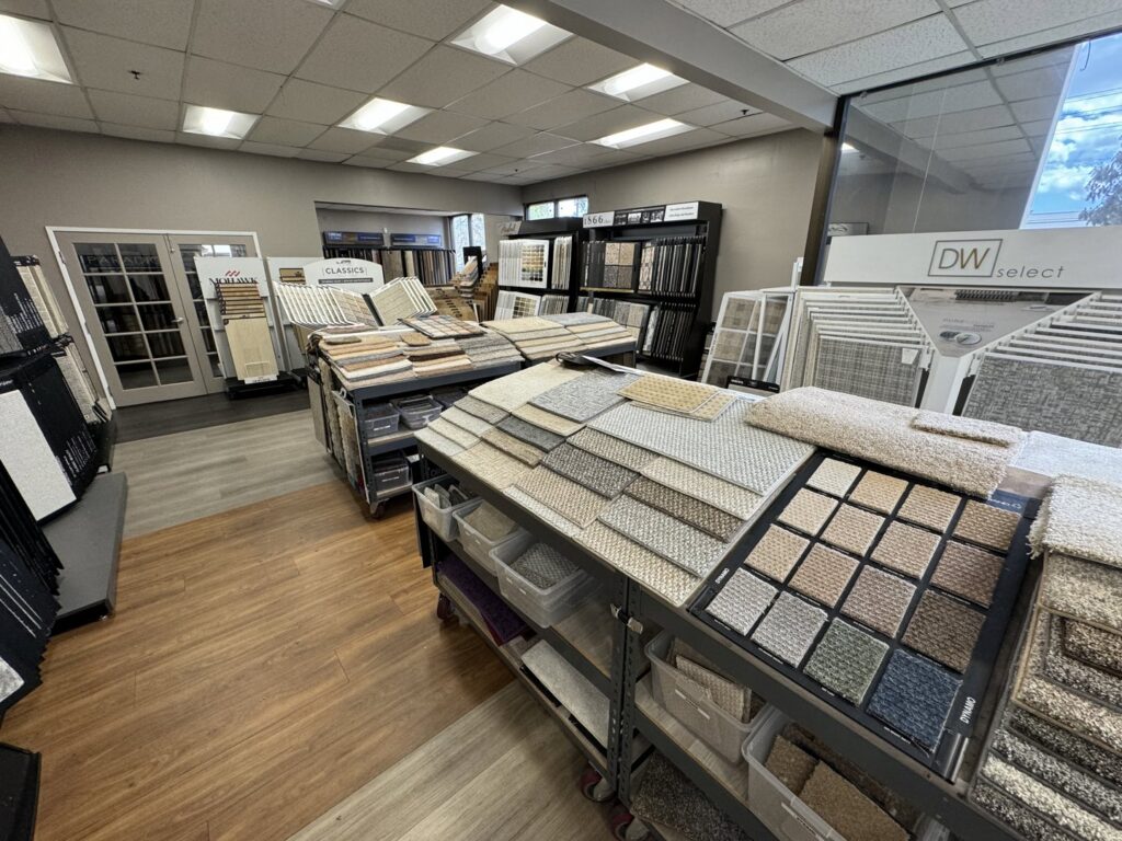A bright and organized carpet and flooring showroom with various displays at Sy's Discount Carpets in Los Angeles, CA