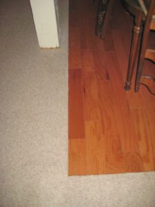 A seamless transition from newly installed beige carpet to hardwood flooring by Big Orange Country Carpets & Concepts in Knoxville, TN.