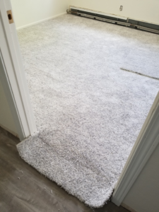 Carpet installation nearing completion at a doorway by Rendon Flooring in Green River, WY.