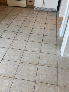 A close-up of a carpet edge with a visible tack strip next to a tiled floor, showing carpet installation work by B's Carpet Cleaning in Saint George, UT.