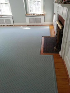 Precision carpet installation around a fireplace hearth and transition to hardwood by Karpet Klinic Inc. in Cranston, RI