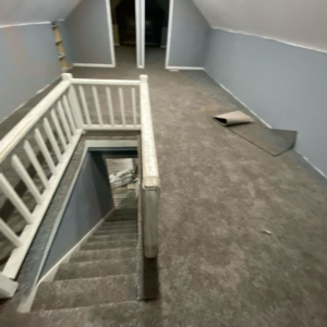 A hallway and staircase with new grey carpet installation, demonstrating work by HK Carpet Doctors in Sterling Heights, MI
