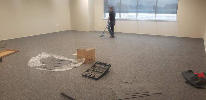 Carpet installation in progress in a large commercial space by Experience Carpet Installers in Dallas, TX.