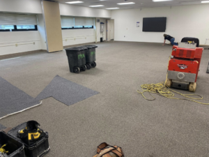 Carpet installation in progress with tools and a worker by Floor Perfection of Arkansas in Conway, AR