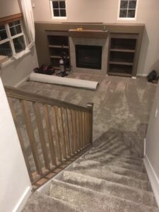 Carpet installation in progress in a living room, with a roll of carpet, by Carpet Connection of Denver in Aurora, CO.