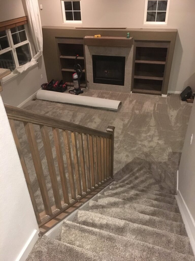 Carpet installation in progress in a living room, with a roll of carpet, by Carpet Connection of Denver in Aurora, CO.