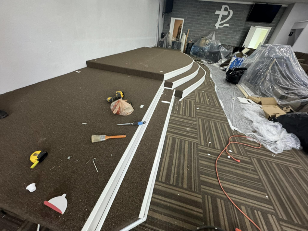 Carpet installation in progress on a raised stage area by Global Flooring Enterprise in Miami, FL.