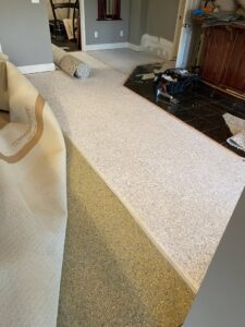 New carpet being installed with padding visible underneath by Carpet Kings Cleaning & Restoration in Olathe, KS.