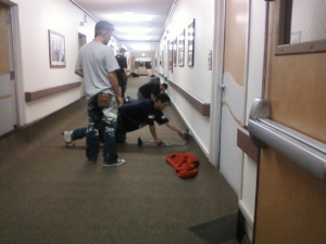 Workers performing carpet installation or repair in a commercial hallway by JEMS Carpet Service in Rio Rancho, NM.