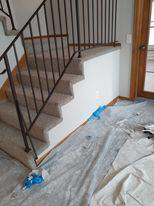 Carpet installation on stairs with a drop cloth on the floor by Blue Star Flooring in Euless, TX