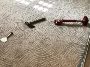 Carpet installation tools laid on newly installed patterned carpet by Bentley Carpet Installation & Sales in Phoenix, AZ.