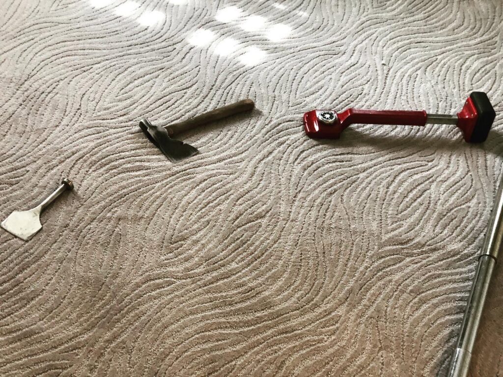 Carpet installation tools laid out on a newly installed patterned carpet by Bentley Carpet Installation & Sales in Phoenix, AZ
