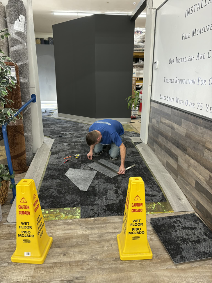 A carpet installer cutting tiles during an installation project for Onondaga Flooring in Syracuse, NY.