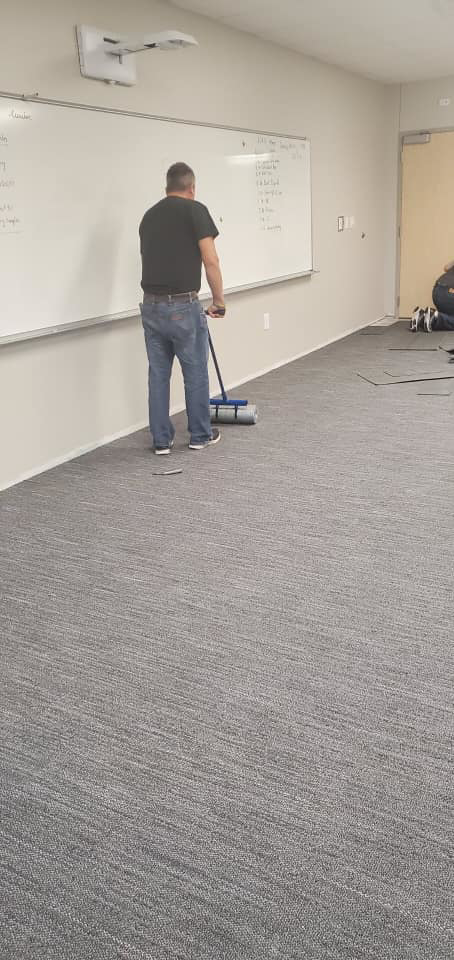A carpet installer working on new carpet tile installation for Experience Carpet Installers in Dallas, TX.