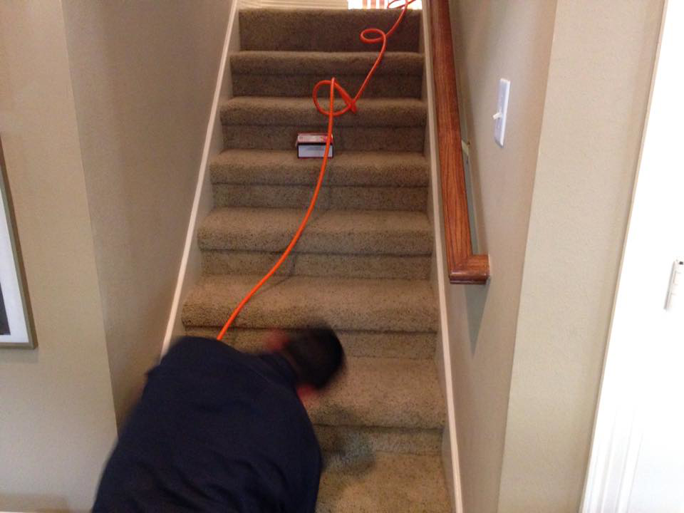 A carpet installer from The Carpet Specialists working on carpeted stairs in Houston, TX.