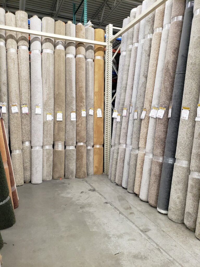 Large rolls of various carpets stacked in the inventory section of The Floor Trader Oklahoma in Oklahoma City, OK.