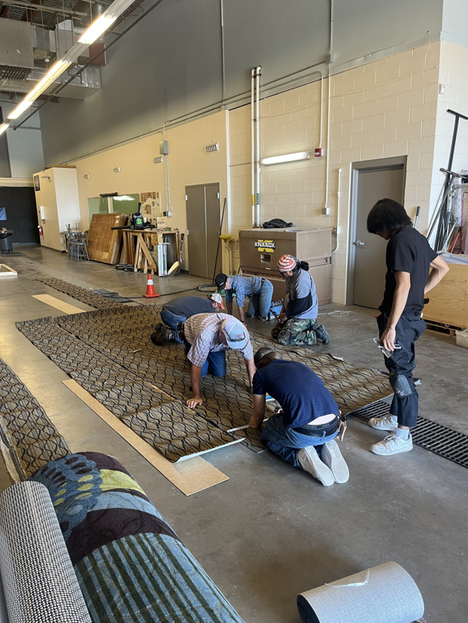 Carpet contractors laying out and seaming carpet rolls during an installation project by Floors & More Abbey Flooring in Great Falls, MT.