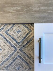 Close-up of a carpet sample alongside wood and cabinet materials for selection at Adda Carpet and Flooring in New Orleans, LA.