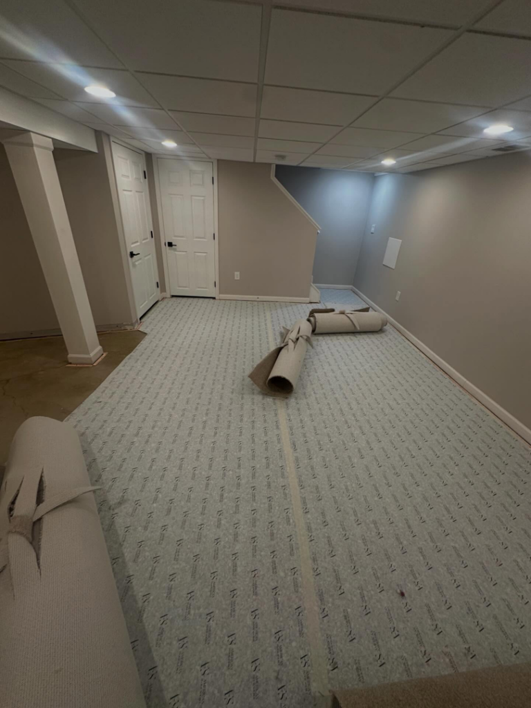 Carpet padding and rolls of new carpet being installed in a basement by Ordonez Flooring and Installation in Lewis Center, OH.
