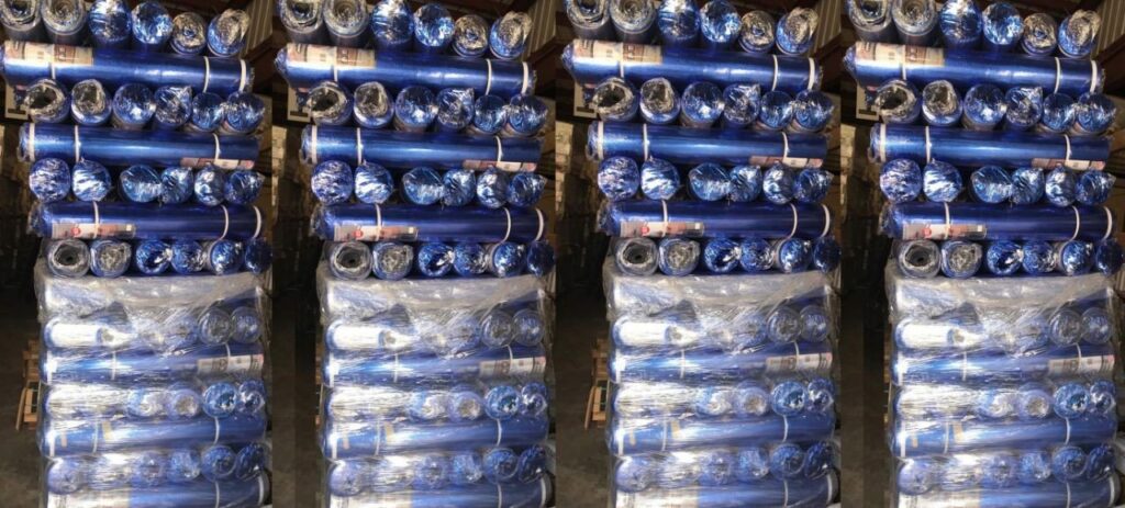 Stacks of blue carpet padding rolls in a warehouse, ready for installation by GC Flooring - Houston, TX