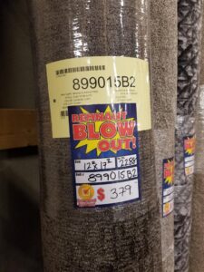 A carpet remnant roll with a 'Blow Out!' sale tag at Taylor Carpets & Flooring in Provo, UT