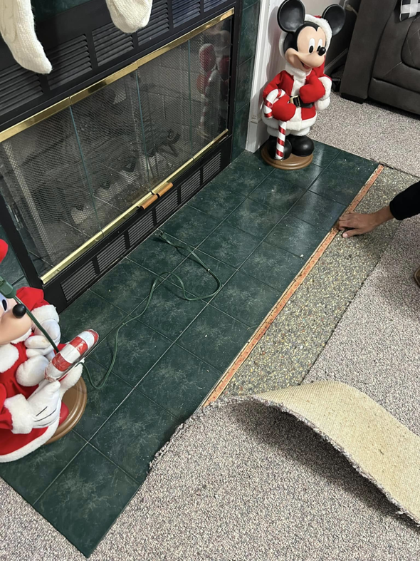 Carpet being removed or installed around a tiled fireplace hearth by Image Group Flooring in Leesville, SC.