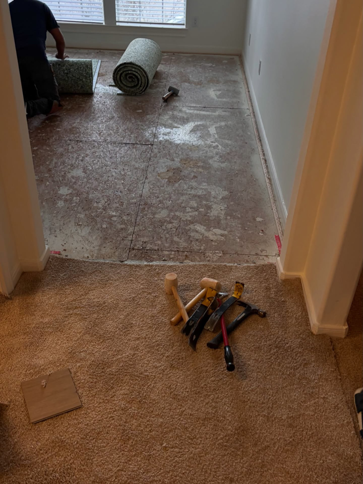 Carpet removal and subfloor preparation during a flooring project by The Land Flooring in Spring, TX.
