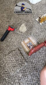 Carpet repair tools on a damaged carpet section, showing a repair job by Carpet Kings Cleaning & Restoration in Olathe, KS.