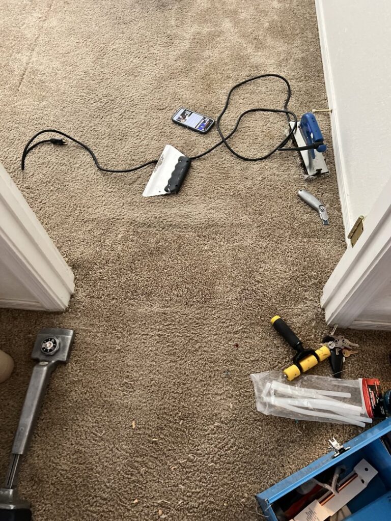 Various carpet repair and installation tools laid out on a carpeted floor by Tucson Carpet Repair & Cleaning in Tucson, AZ.