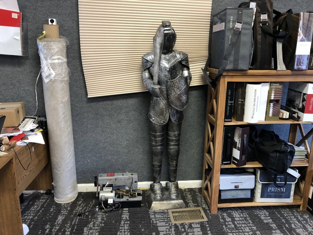 A large roll of carpet and a carpet binding machine in the office of Carpet Maven Flooring in Woodbridge, NJ.