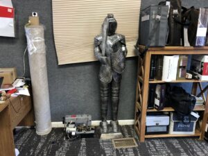 A large roll of carpet and a carpet binding machine in the office of Carpet Maven Flooring in Woodbridge, NJ.