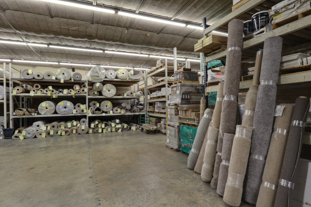 Warehouse storage area with numerous carpet rolls ready for installation at Floor Depot San Antonio, TX