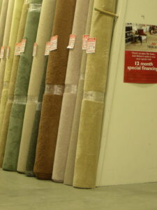 Numerous rolls of carpet leaning against a wall in the store at Craft Rug Mills in Easton, PA.