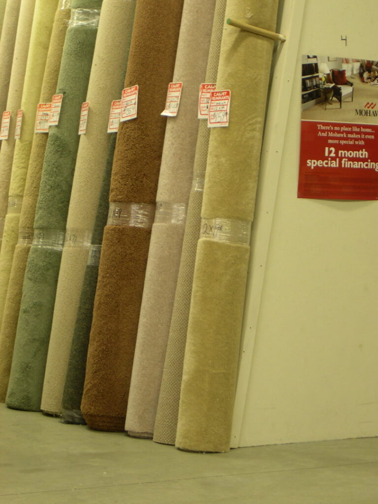 Numerous rolls of carpet leaning against a wall in the store at Craft Rug Mills in Easton, PA.