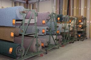 Colorful carpet rolls neatly arranged on display racks at Craft Rug Mills in Easton, PA.