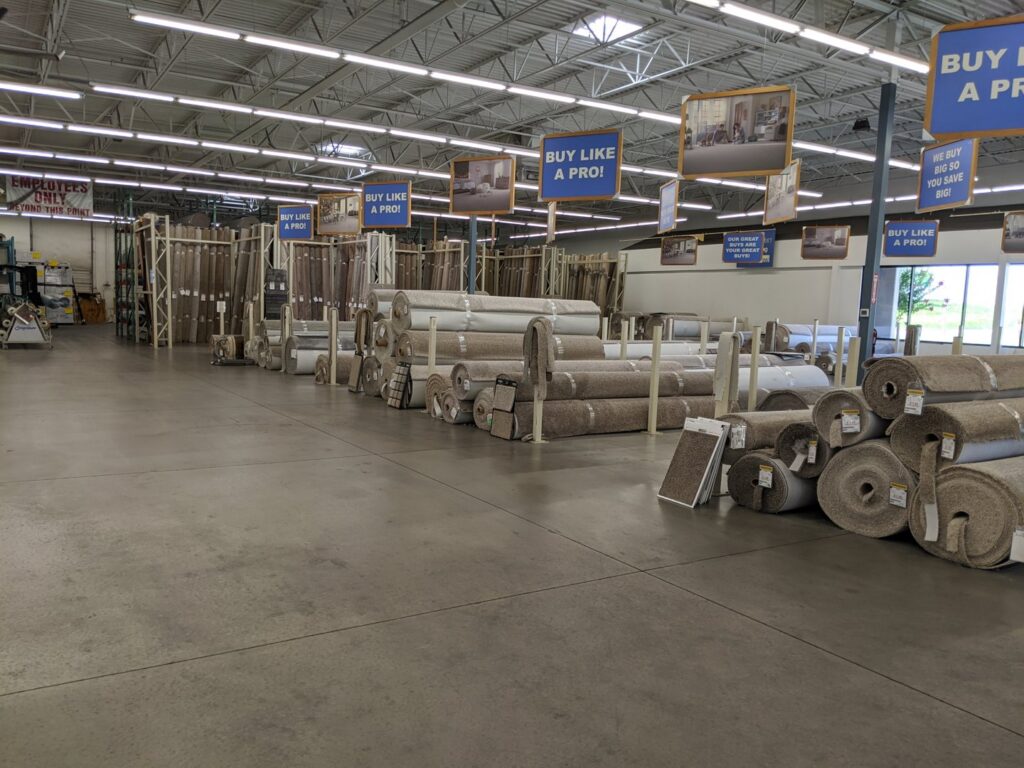 Rows of various carpet rolls displayed in the showroom at The Floor Trader Oklahoma in Oklahoma City, OK.