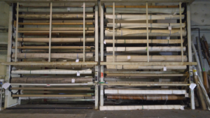 Large rolls of carpet and flooring materials stored on racks at Home Carpet Distributors in Columbus, OH.