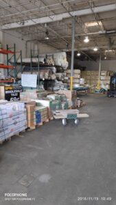 Large rolls of carpet stacked in the warehouse of Dunedin Floors & Granite, ready for installation in Tampa, FL.