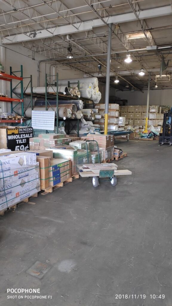 Large rolls of carpet stacked in the warehouse of Dunedin Floors & Granite, ready for installation in Tampa, FL.