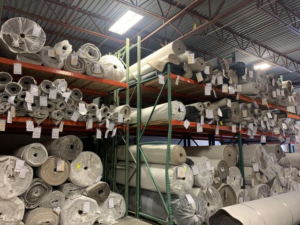 Large rolls of carpet stored in a warehouse at IDF The Floor Store in Idaho Falls, ID, ready for installation.