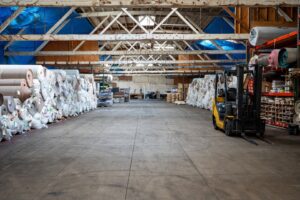 A large warehouse filled with rolls of carpet and flooring materials at Mill Sales Co. in Los Angeles, CA