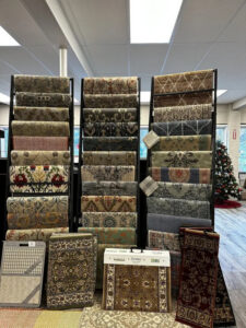 A showroom display featuring numerous rolled carpet and rug samples at Morency Flooring in New Bedford, MA.