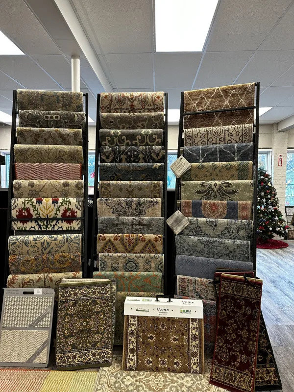 A showroom display featuring numerous rolled carpet and rug samples at Morency Flooring in New Bedford, MA.