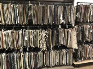 A wide selection of carpet and rug samples hanging on display at Artifacts Fine Rugs and Flooring in South Salt Lake, UT.